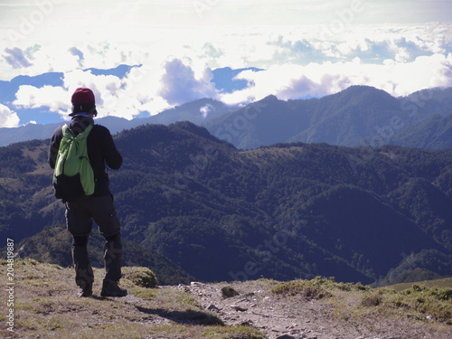 A male hiker standing on a platform and enjoying the beautiful alpine landscape of Taiwan.