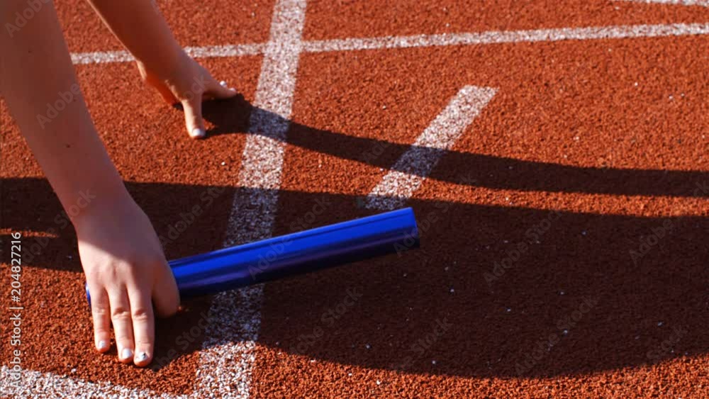 Female runner putting hands for relay running, 75 fps slow motion