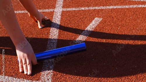 Female runner putting hands for relay running, 75 fps slow motion photo