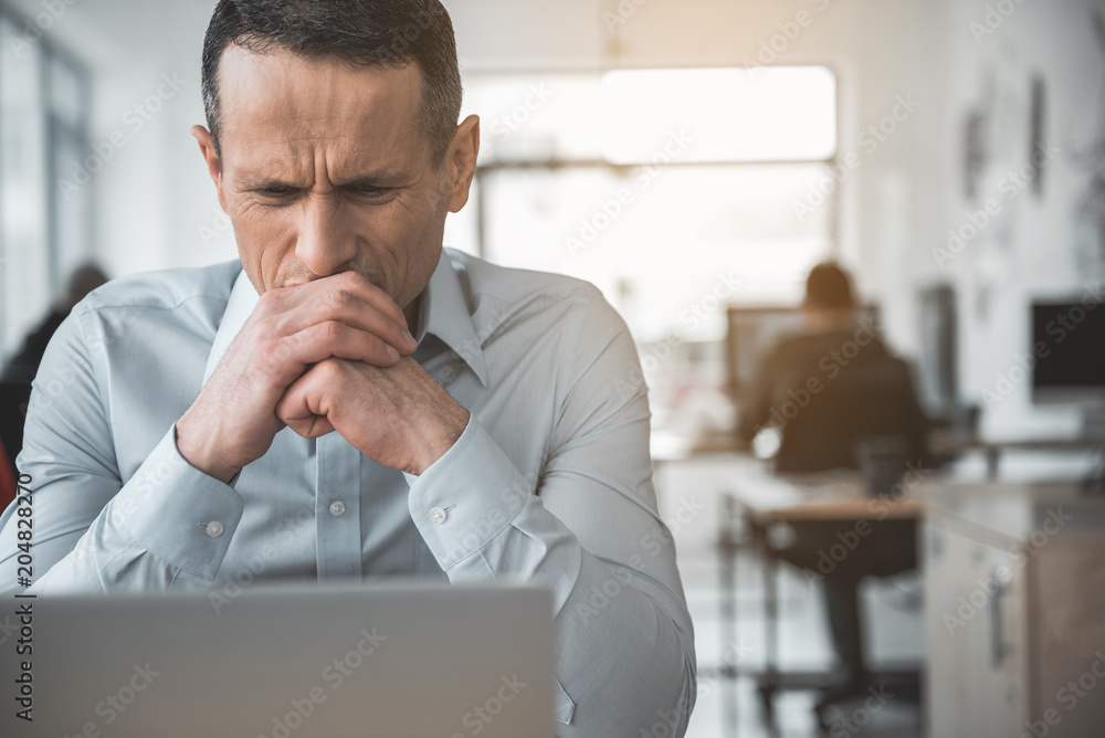 Φωτογραφία Portrait of dissatisfied male employer looking at gadget during job