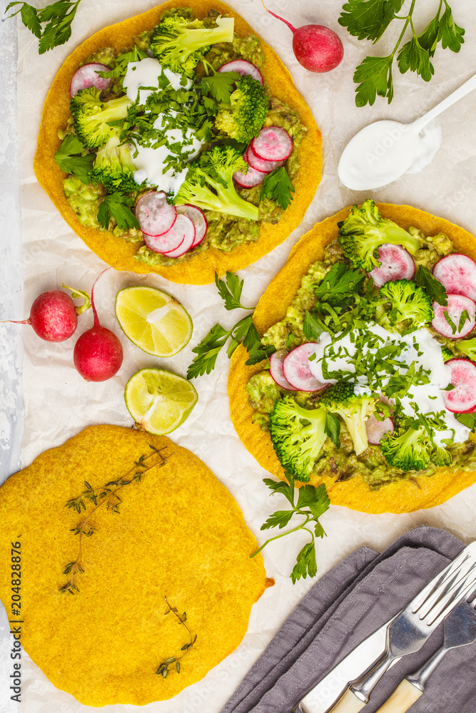 Vegan tacos (pizza, pita) with radish, broccoli and guacamole, top view. Healthy vegan food concept.