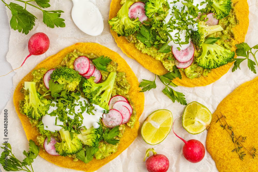 Vegan tacos (pizza, pita) with radish, broccoli and guacamole, top view. Healthy vegan food concept.