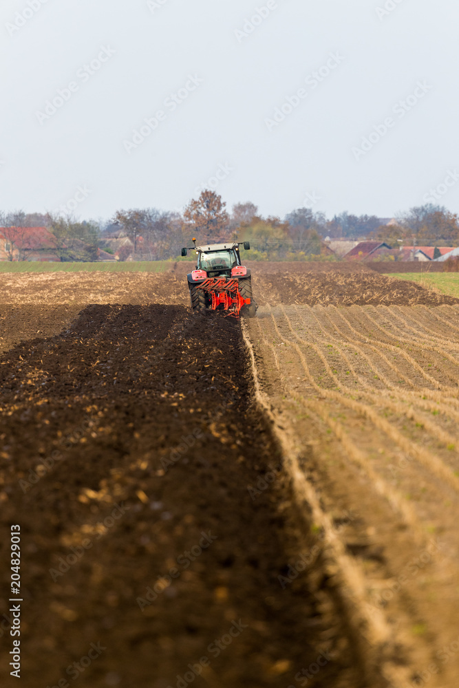 Obraz premium Farmer plowing stubble field