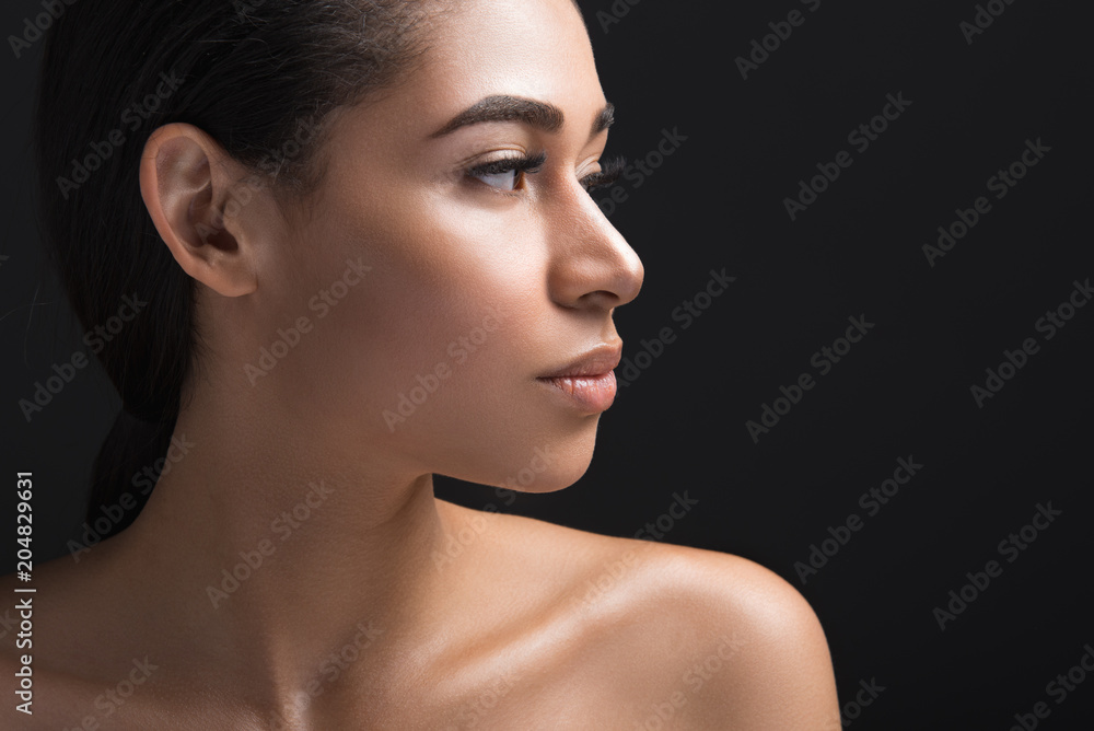 Close up of calm woman showing beautiful profile of her face. Copy space in right side. Isolated on black background Close up of calm woman showing beautiful profile of her face. Copy space in right side. Isolated on black background