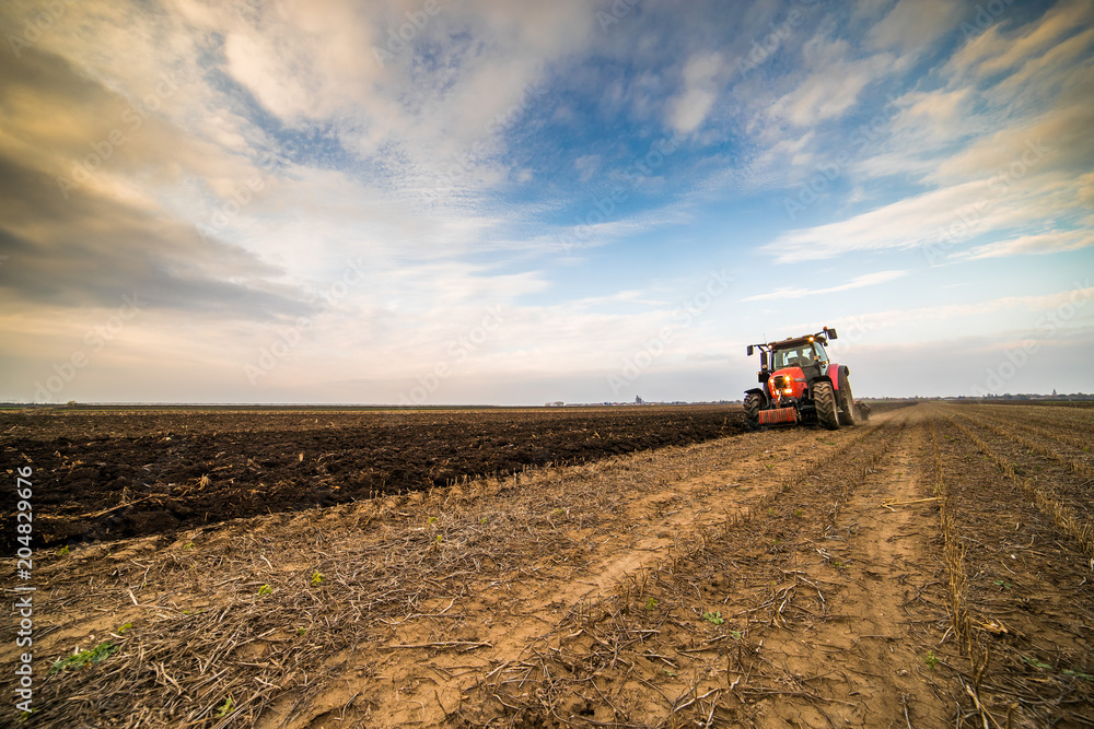 Farmer plowing stubble field Farmer plowing stubble field