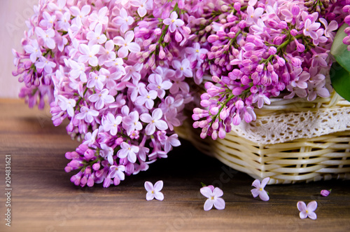 lilac in basket on wooden table 