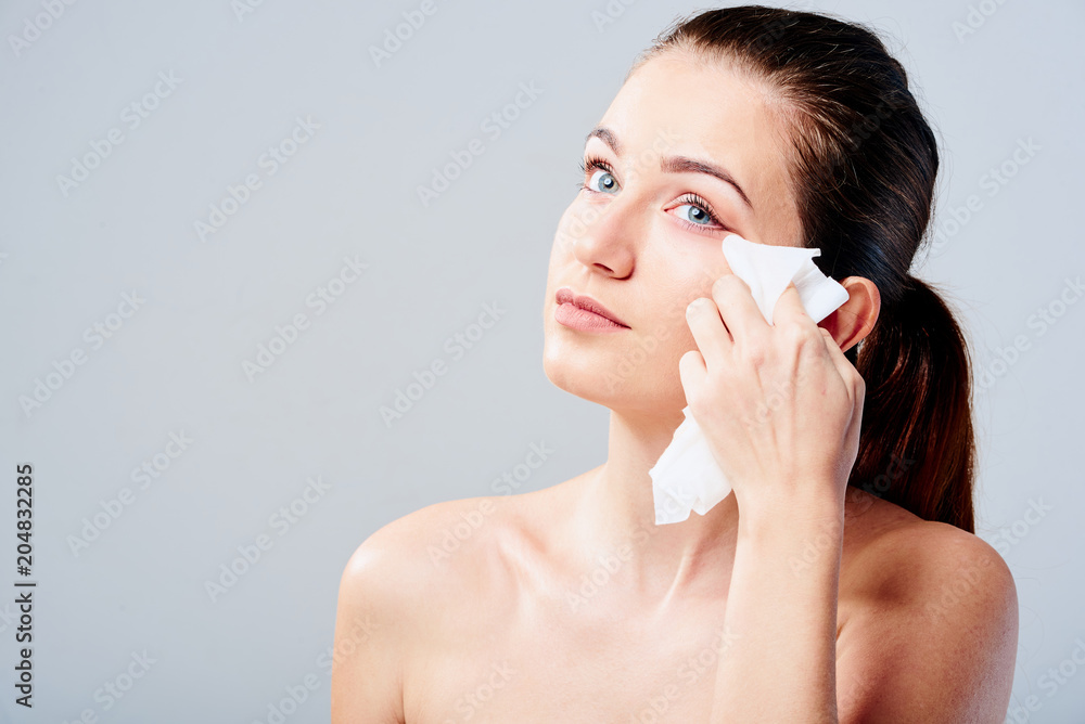 Portrait of a young woman who cleans her face with wet wipes Portrait of a young woman who cleans her face with wet wipes