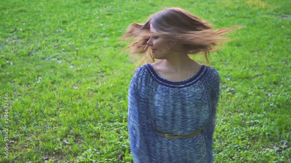 Young attractive girl twirls hair in the park closeup. slow motion Young attractive girl twirls hair in the park closeup. slow motion