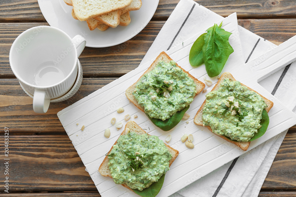 Toasts with tasty spinach sauce on table Toasts with tasty spinach sauce on table