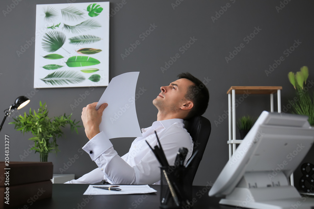 Obraz premium Young man feeling hot in office
