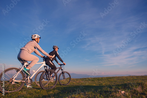 Fototapeta Naklejka Na Ścianę i Meble -  Happy mountainbike couple outdoors have fun together on a summer afternoon sunset