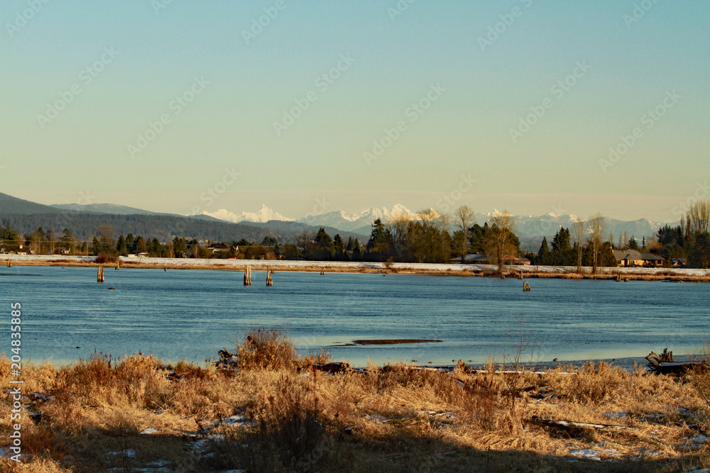 A view of the river with snow covered peaks in the background.