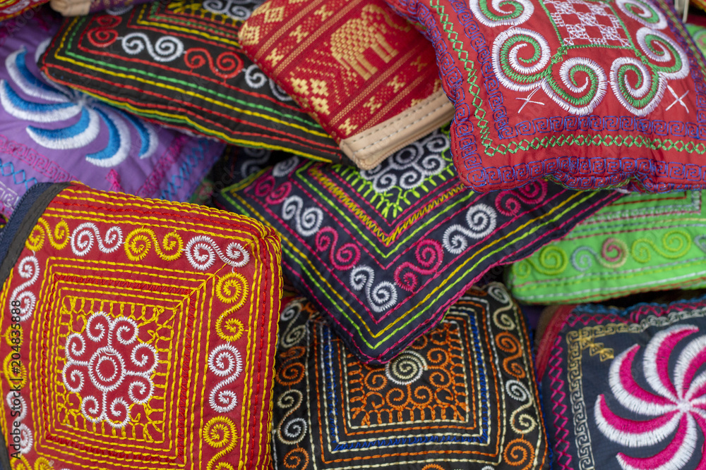 Cambodian traditional textile. Simple native ornament sewed on dark background. Colorful embroidery texture Cambodian traditional textile. Simple native ornament sewed on dark background. Colorful embroidery texture