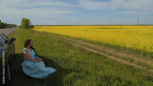 Wallpaper Mural Charming brunette enjoy beautiful view on yellowe flowers sitting on roadside Torontodigital.ca