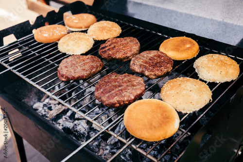 Buns and meat patties grilled for outdoors barbecue