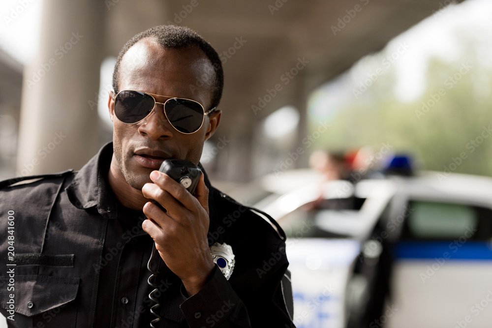 african american police officer talking by walkie-talkie radio set Photos |  Adobe Stock