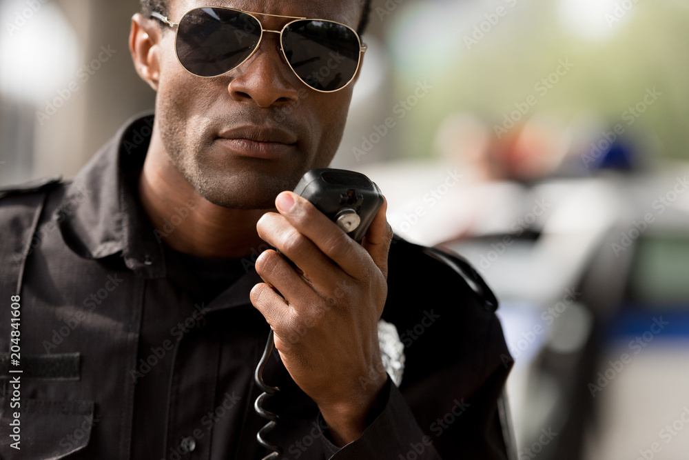 close-up portrait of african american police officer talking by walkie- talkie radio set Stock Photo | Adobe Stock