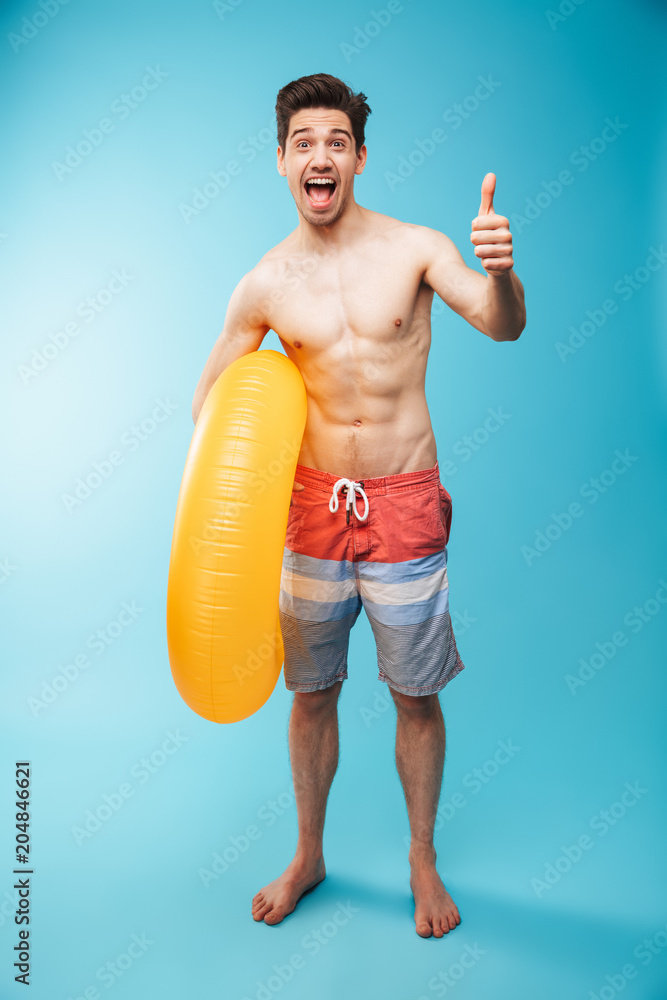 Full length portrait of an excited young shirtless man