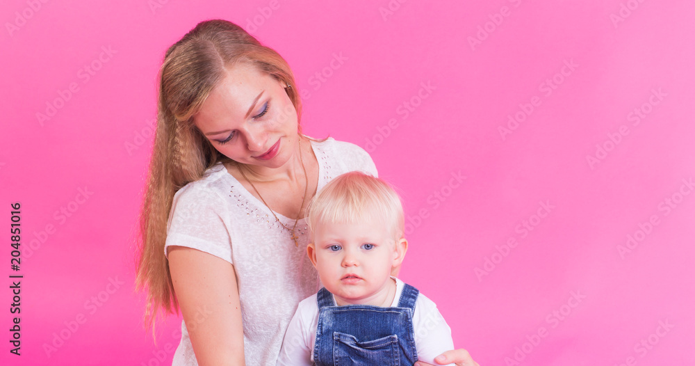 happy little girl and her mother having fun over pink background happy little girl and her mother having fun over pink background