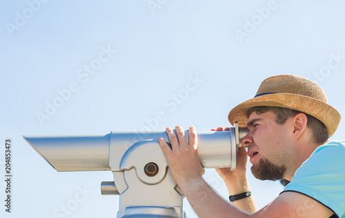 Man in the hat looking telescope photo