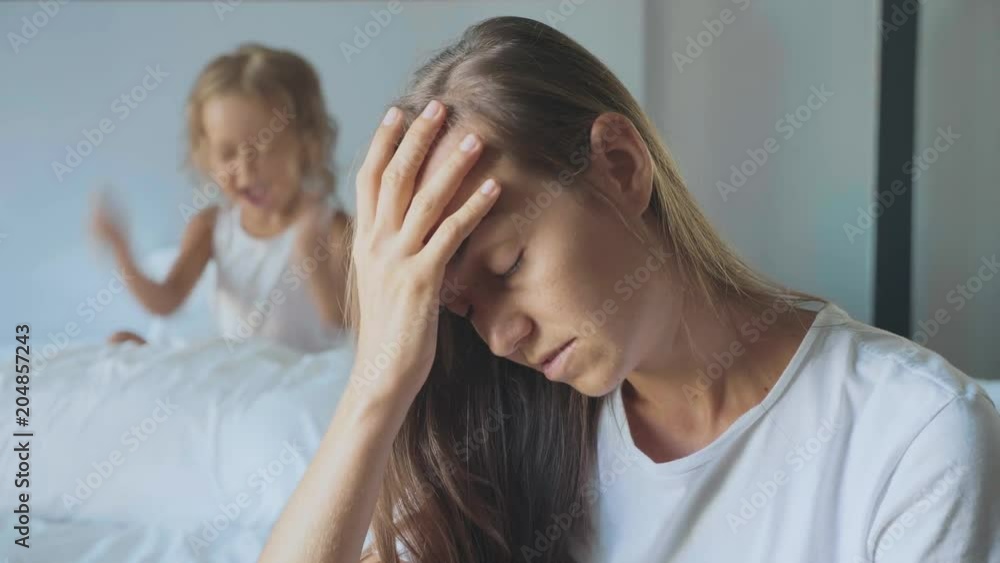 Upset mother with angry little child screaming pillow on the background Upset mother with angry little child screaming pillow on the background
