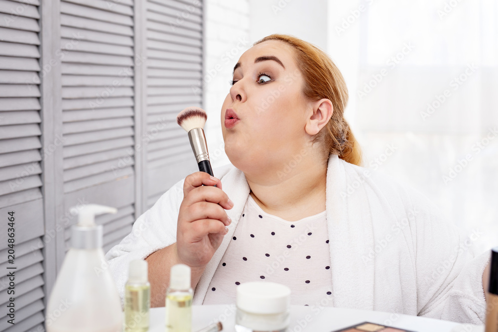 I am pretty. Inspired stout woman wearing a bathrobe and blowing at a makeup brush I am pretty. Inspired stout woman wearing a bathrobe and blowing at a makeup brush