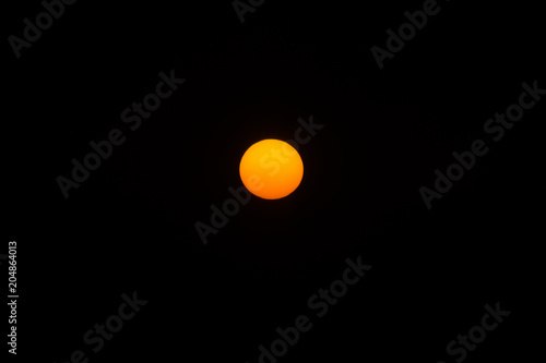 Orange sun in the dark sky.