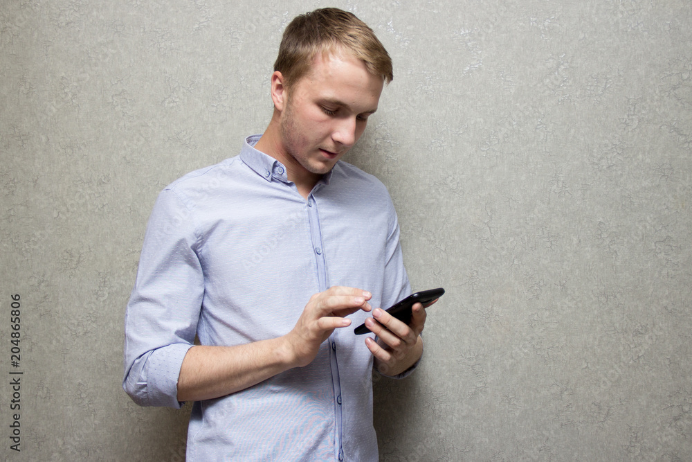 guy in shirt looking at mobile phone guy in shirt looking at mobile phone