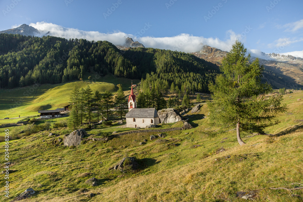 St. Spirito little church among a wide green meadow in Casere , Aurina
