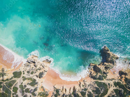 Aerial view of sandy beach and ocean with beautiful clear turquoise water.