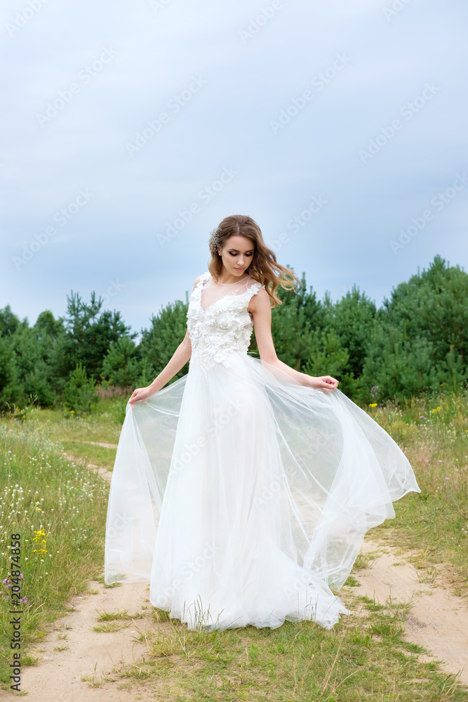 young pretty bride in white wedding dress outdoors, make up and hairstyle