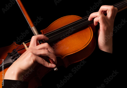 Violin and bow in hands of violinist, isolated on black