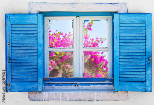 Beautiful vintage Greek window with blue shutters. Typical Greek picture.