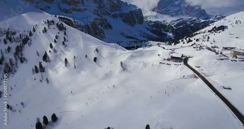 Aerial, breathtaking snowy mountains, ski tracks in winter Alps in Italy