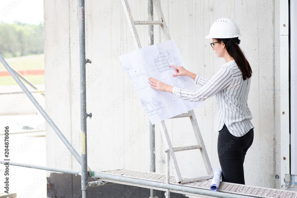 Frau mit Plänen auf einer Baustelle Frau mit Plänen auf einer Baustelle