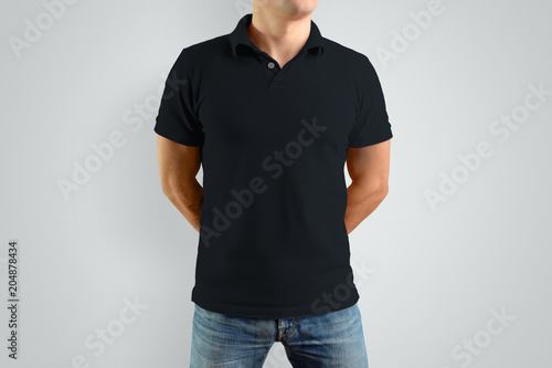 Mockup  black polo shirt on a strong guy. Isolated on a gray background.