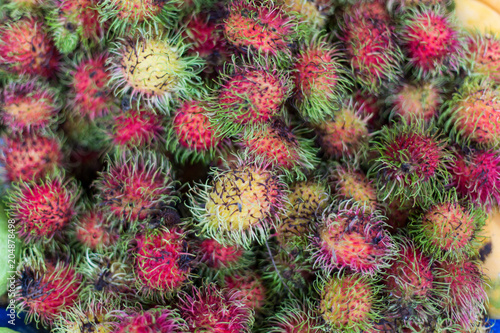 close up red rambutan on top view and it's many rambutans background