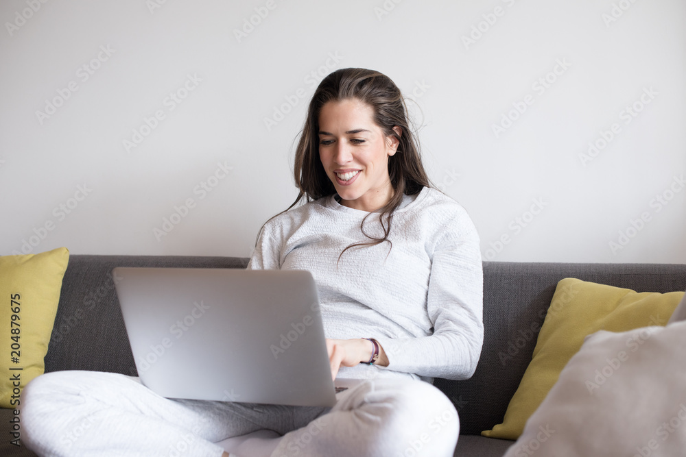 Woman sitting in living room and working on laptop Woman sitting in living room and working on laptop