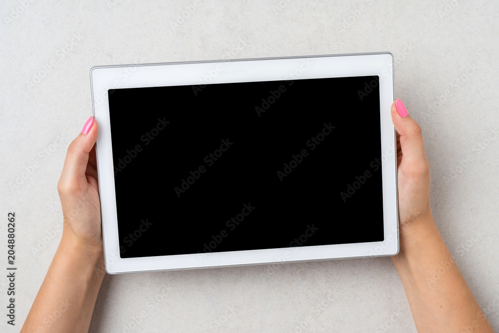 Woman holding white digital tablet. Close up