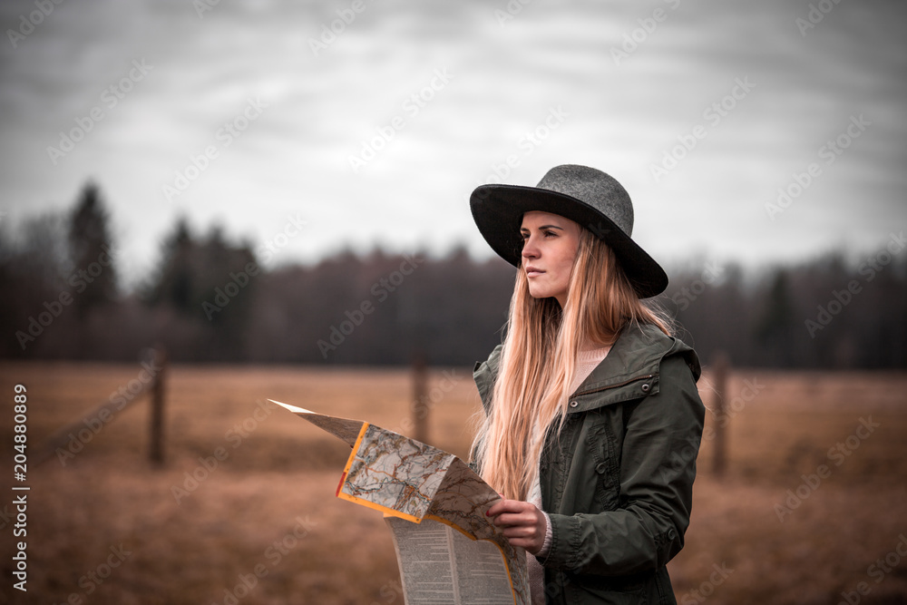 Rural scene with traveler woman in hat with map, melancholic autumn mood