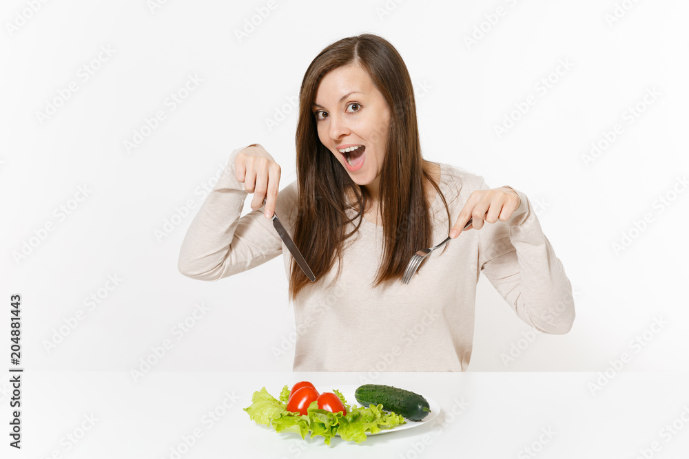 Vegan woman at table with leaves salad lettuce, vegetables on plate isolated on white background. Proper nutrition, vegetarian food, healthy lifestyle dieting concept. Advertising area with copy space Vegan woman at table with leaves salad lettuce, vegetables on plate isolated on white background. Proper nutrition, vegetarian food, healthy lifestyle dieting concept. Advertising area with copy space