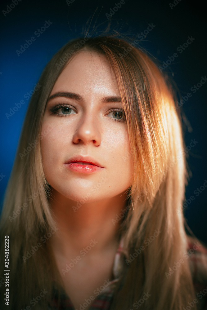Fototapeta premium portrait smiling girl on blue background in studio