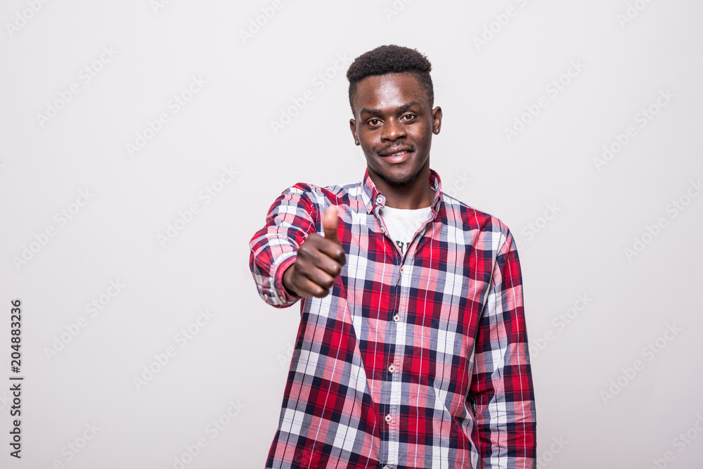Portrait of young african-american man showing thumb up and smiling, over white Portrait of young african-american man showing thumb up and smiling, over white