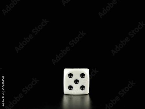 Game die isolated against black background, face with number five