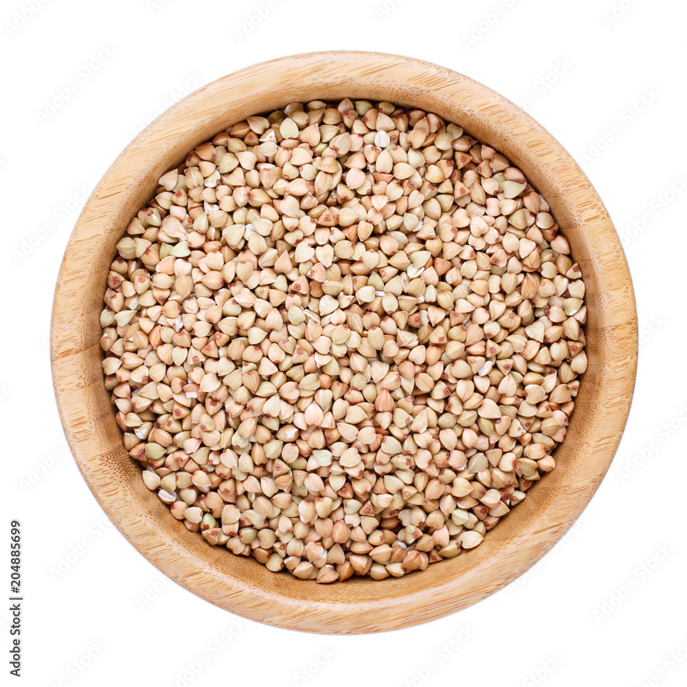 Raw organic green buckwheat grains in wooden bowl isolated on white. Top view. Raw organic green buckwheat grains in wooden bowl isolated on white. Top view.