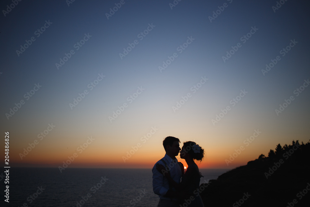 girlfriend and boyfriend hugging at sunset near the sea