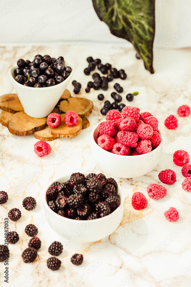 Raw raspberries and wild black, blackberries in white cups. Antioxidant food. Summer fruit, berries. Detox diets and healthy food concept. Raw raspberries and wild black, blackberries in white cups. Antioxidant food. Summer fruit, berries. Detox diets and healthy food concept.