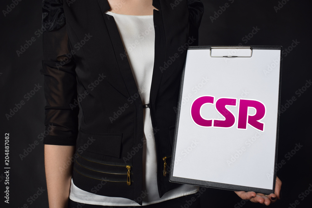 In the hands of a businessman a notebook with the inscription:CSR In the hands of a businessman a notebook with the inscription:CSR