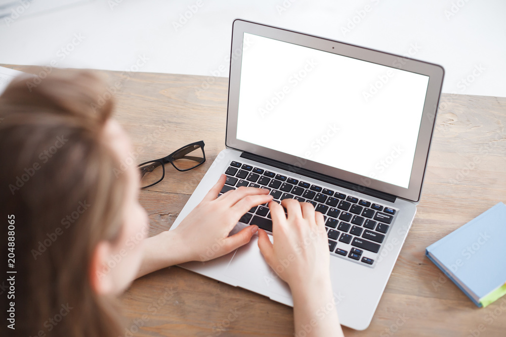 female hands typing on computer keyboard. Woman working on laptop sitting at work table. Glasses and Notes lying on wooden table. Laptop computer with blank screen for your promotional text female hands typing on computer keyboard. Woman working on laptop sitting at work table. Glasses and Notes lying on wooden table. Laptop computer with blank screen for your promotional text