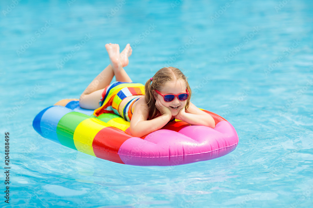 Child on inflatable float in swimming pool.